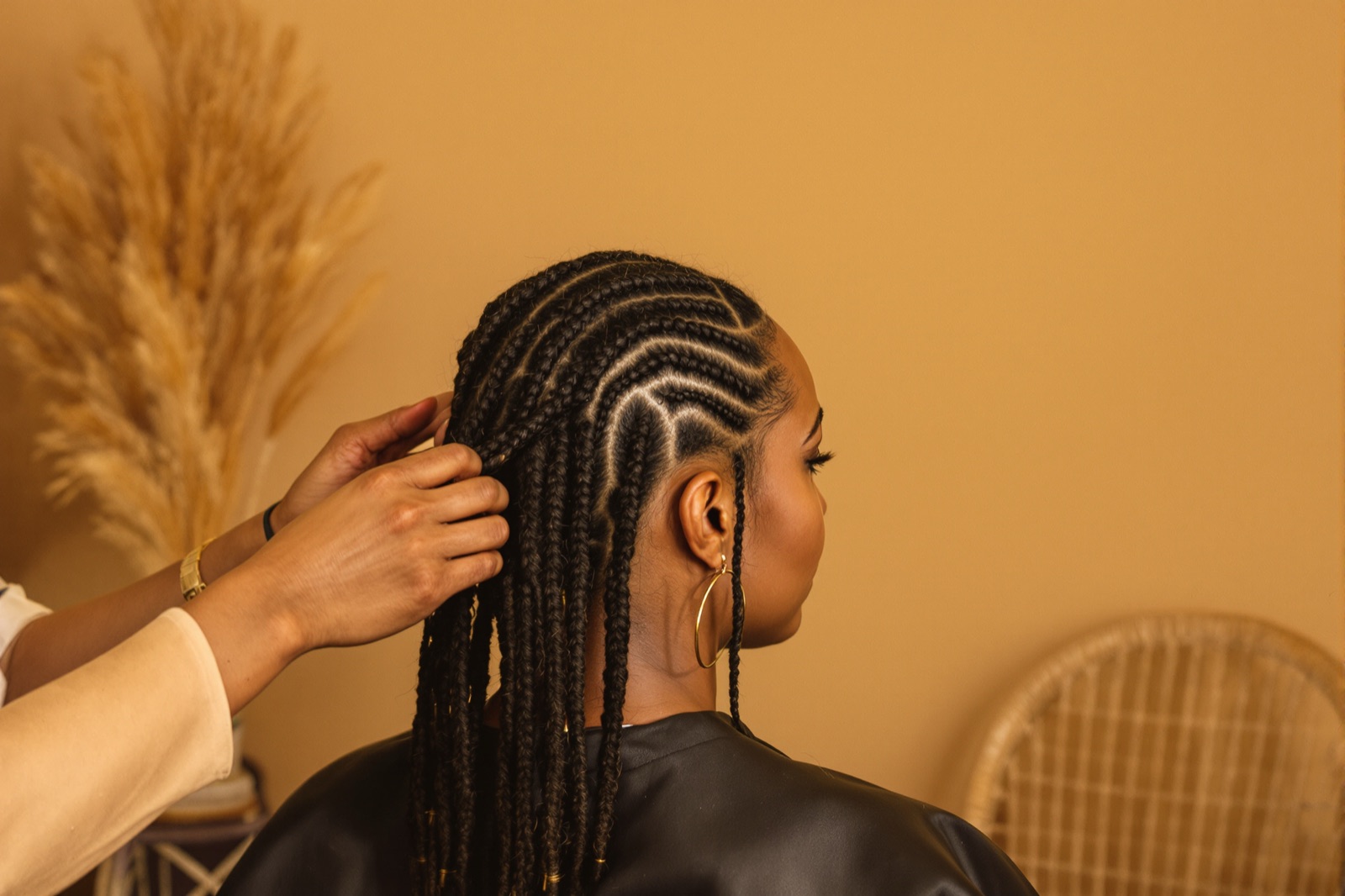 A client having her hair braided at the studio