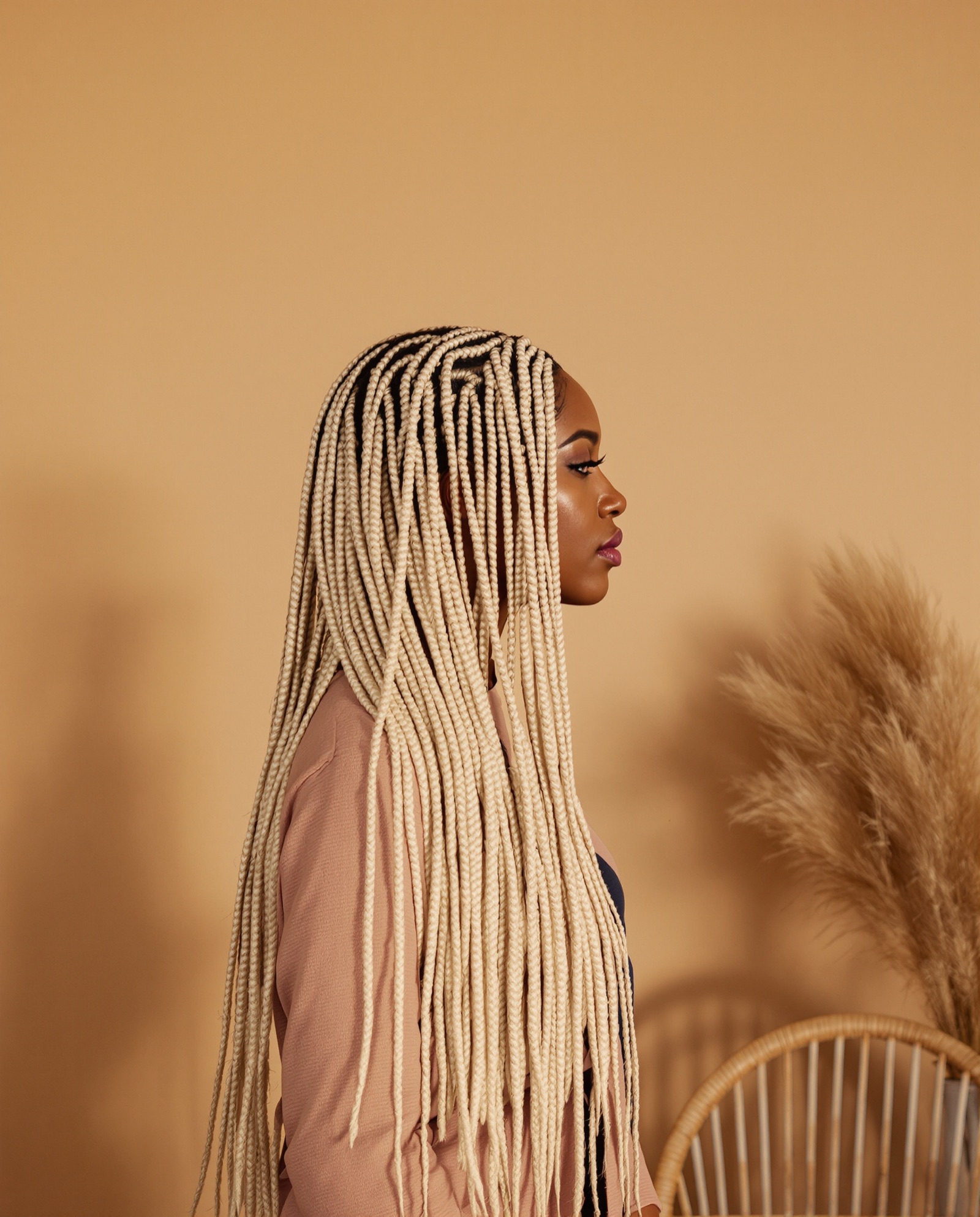 Honey-blonde knotless box braids, waist length, in profile