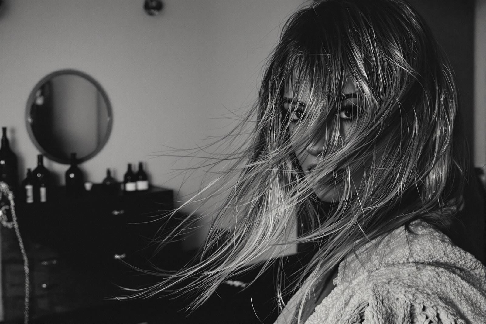 Black-and-white editorial portrait, hair falling softly across the face